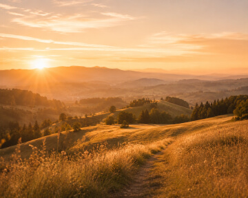 Sonnenaufgang über einer hügeligen Landschaft.